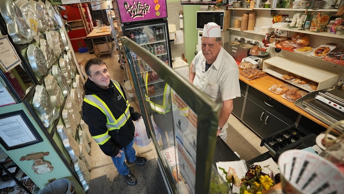 Éric Langlois derrière la caisse de la bouangerie.