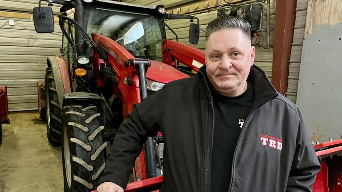Éric Tremblay devant son tracteur.