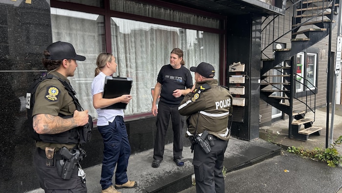 Éric Turgeon parle avec une inspectrice et deux policiers.