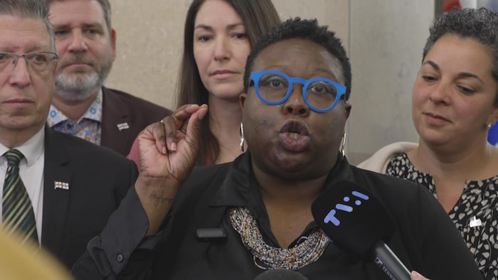 Une femme lors d'une mêlée de presse.