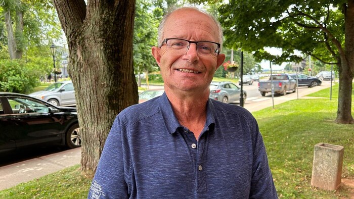 Le ministre des Transports et de l’Infrastructure de l'Île-du-Prince-Édouard Ernie Hudon dehors en été dans un quartier urbain.