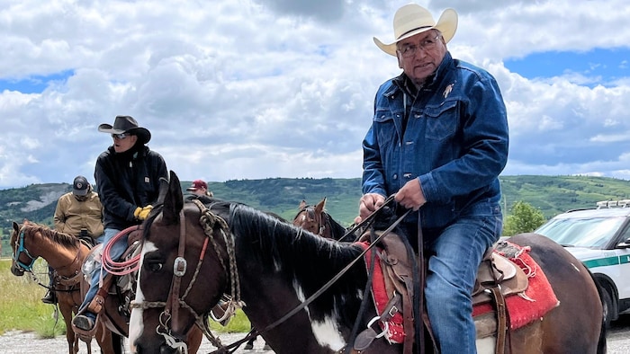 Un homme assis sur un cheval. 