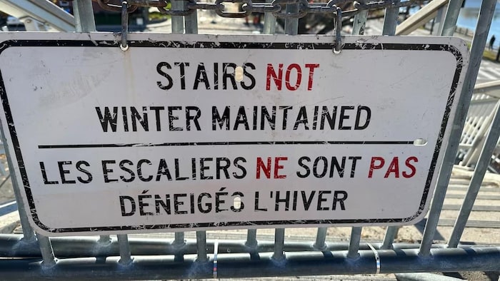 Un panneau où il est inscrit : Les escaliers ne sont pas déneigés l'hiver.