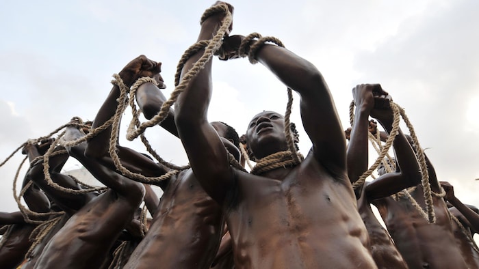 Unos hombres simulan una escena de esclavitud en Abiyán, en el marco de las celebraciones del 50º aniversario de la independencia de Costa de Marfil.