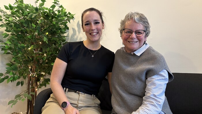 Deux femmes assises sur un divan.