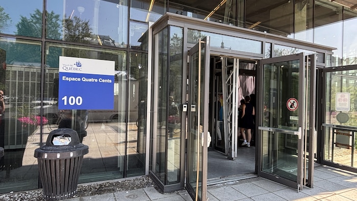 Des passants entrent par les portes vitrées du bâtiment de l'Espace Quatre Cents à Québec.