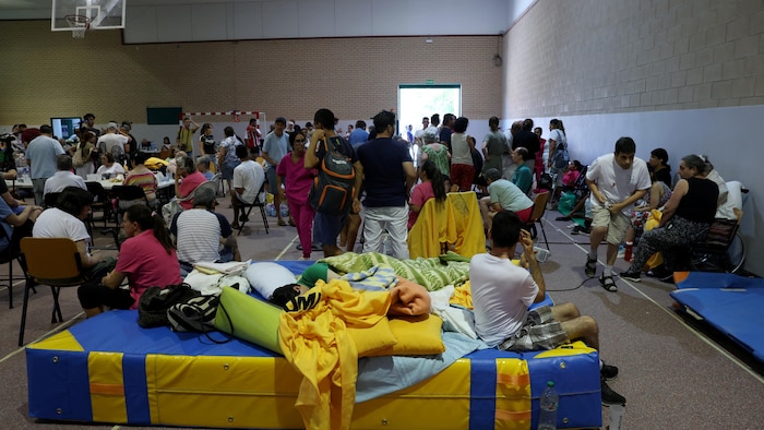 Des habitants évacués en raison d'un incendie de forêt près de San Martín de Valdeiglesias trouvent refuge dans une salle de sport à Villamanta, à l'ouest de Madrid, le 24 juillet 2026.