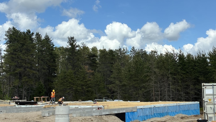 Deux hommes qui travaillent sur un chantier de construction. 