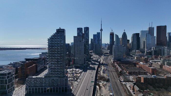 Images aériennes (par drone) de l'Esplanade, avec l'autoroute Gardiner et les voies ferrées en regardant vers le centre-ville par une journée ensoleillée du début du printemps.