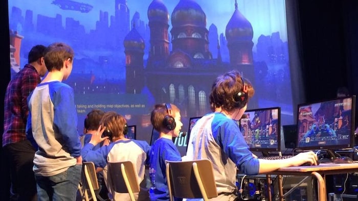 Des jeunes jouent à des jeux vidéo à l'ordinateur. 
