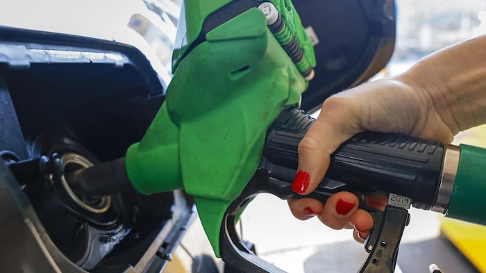 Une automobiliste fait le plein d'essence dans une station-service Jet, filiale de Phillips 66, à Brentford, au nord-ouest de Londres.