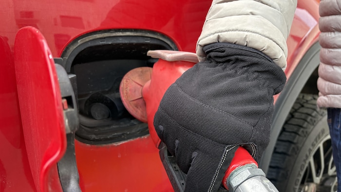 Une personne qui met de l'essence dans sa voiture.