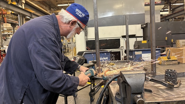 Un homme travaille sur de l'aluminium.