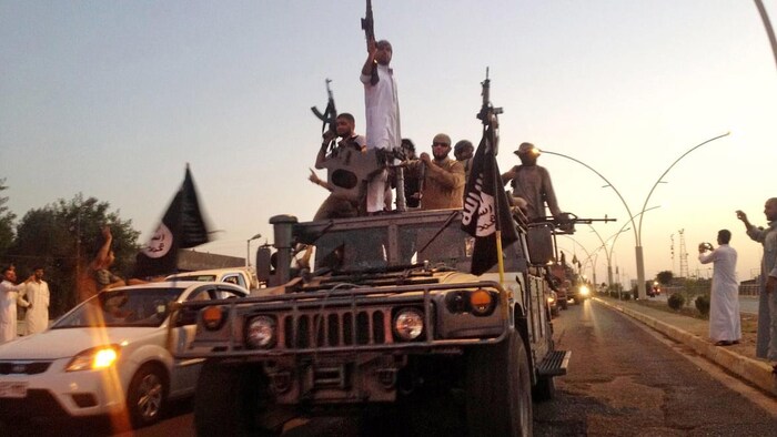 Miembros del Estado Islámico desfilan por las calles, con las armas a la vista. 
