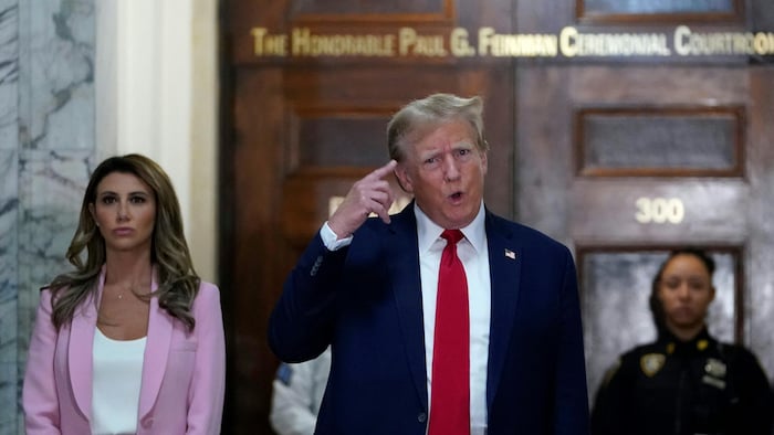 Donald Trump pointe sa tête en tournant la main.