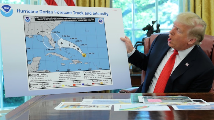 Donald Trump dans le bureau ovale présente une carte.