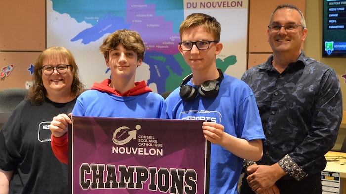 Anthony Gauthier et Ethen Johnston tiennent une bannière avec champions écrit dessus.
