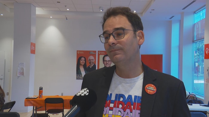 Un homme parle devant la caméra.