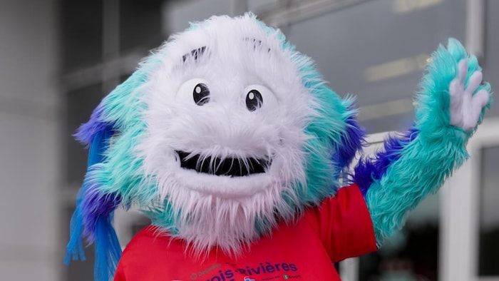 La mascotte qui fait un salut.