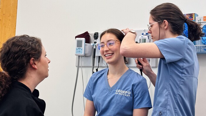 Des étudiants en soins infirmiers simulent un examen sur un patient.