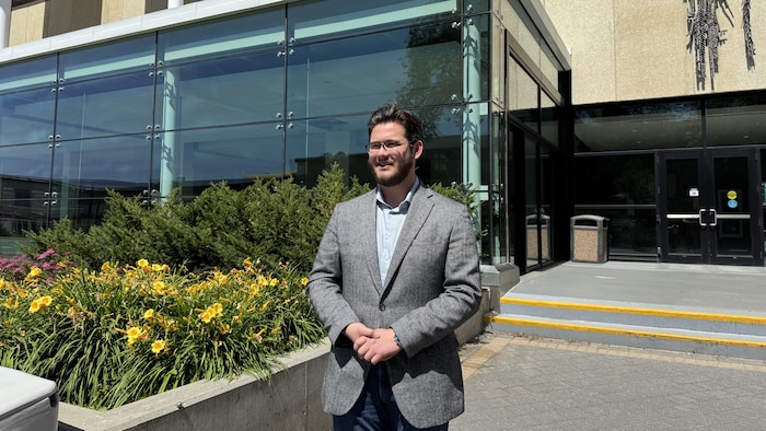 Nathan Tyson à côté de la porte d'entrée de l'université de l'Alberta.