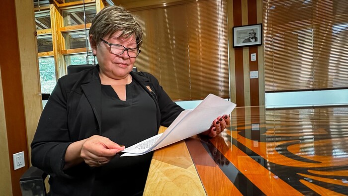 Une femme regarde des papiers.