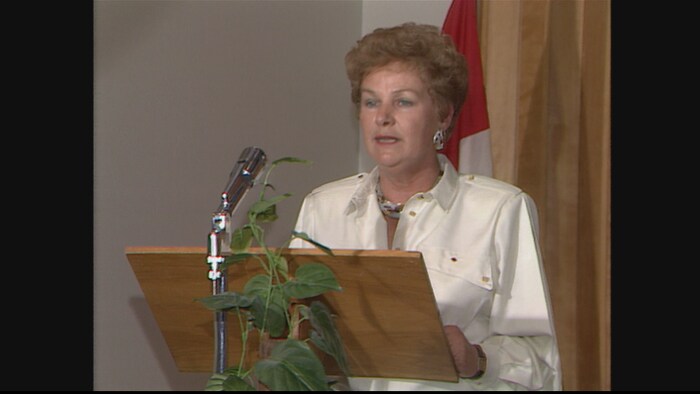 Éva Lachance-Côté, parlait au micro debout derrière un lutin, en 1986. 