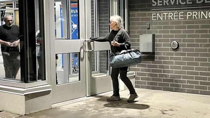 Une femme ouvre la porte d'un centre sportif.
