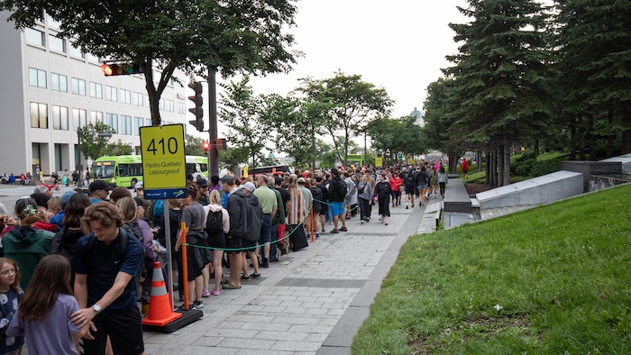 Des centaines de personnes font la file pour prendre l’autobus sur le boulevard René-Lévesque, au centre-ville de Québec, en été.