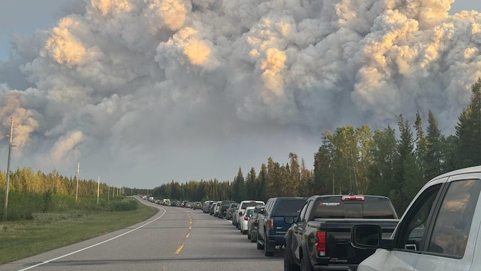 A huge cloud of smoke rises above a line of cars on motorway 2 during the evacuation of the rodent, in Saskatchewan, due to the forest fires on June 2, 2025. state emergency lifted saskatchewan after