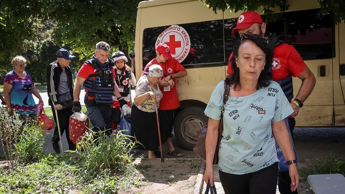 Kızıl Haç çalışanları tahliye edilenlere rehberlik ediyor. 