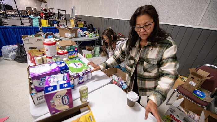 Les deux femmes placent des produits sur des tables.