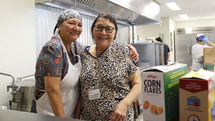 Deux femmes posent dans une cuisine.