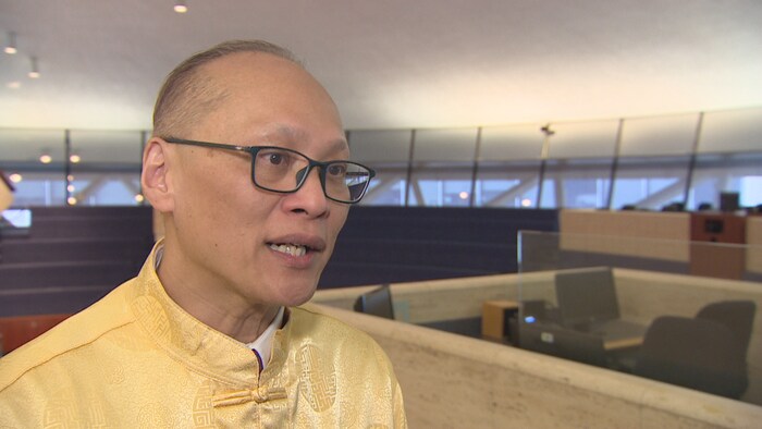 Un homme chinois vêtu d'une tenue traditionnelle jaune, à l'hôtel de ville de Toronto.
