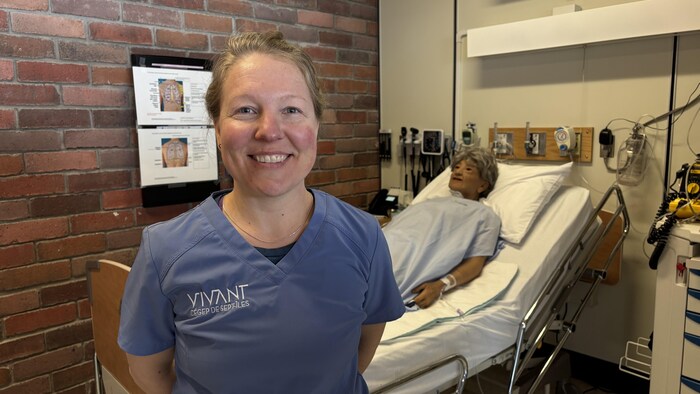 Eve Goulet devant le mannequin réaliste aux soins infirmiers