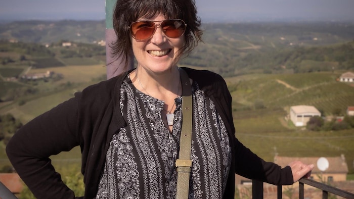 Eveline Chartier devant un vignoble en été. 