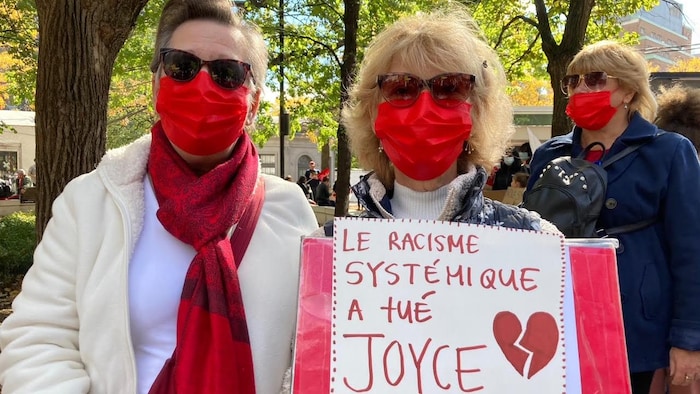 Evelyne Henri et Marcelle Larouche avec une pancarte dénonçant le racisme systémique.