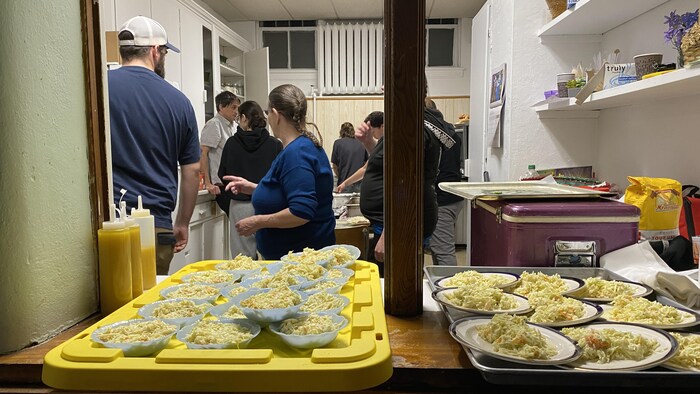 Des repas attendent d'être servis dans la cuisine lors du Noël des oubliés.