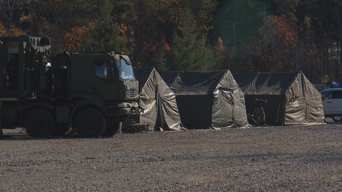 Un véhicule militaire et des abris.