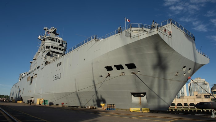 Un navire militaire est amarré au quai.