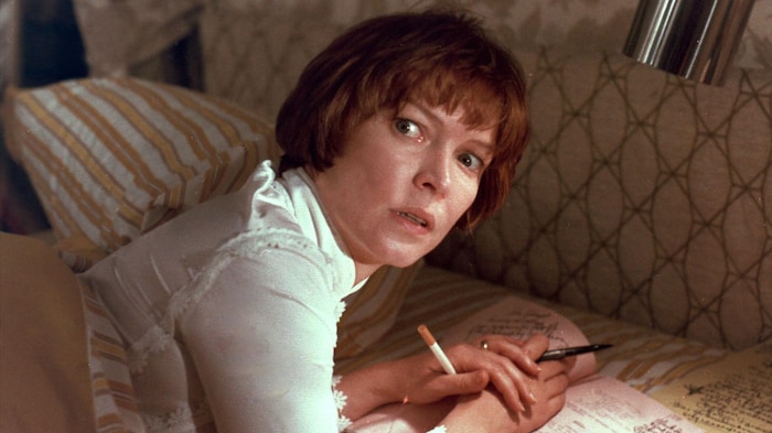 L'actrice dans un rôle tient une cigarette.