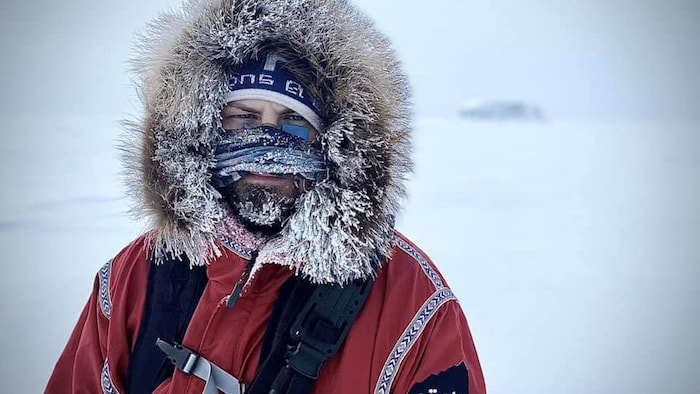 Guillaume Moreau en Arctique, le visage protégé du froid par un cache-cou gelé.