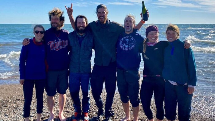 Ils posent en célébrant sur le bord du lac Érié.