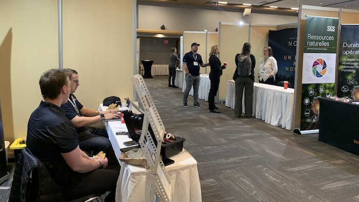 Des exposants sont installés à des tables.