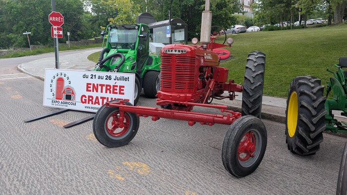 Deux tracteurs et une affiche de l'Expo agricole. 