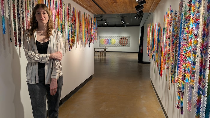 Laura Demers devant des banderoles colorées.