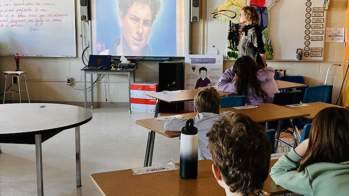 Des jeunes regardent une vidéo sur la vie de Carlo Acutis.