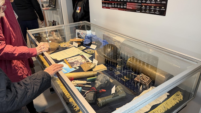 Un présentoir vitré contenant différents objets militaires.