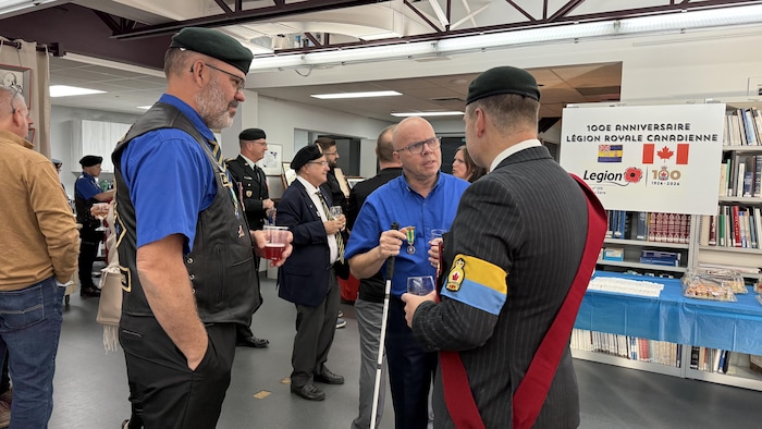 Johnny Larouche, Daniel Viens et Étienne Roy discutent dans une salle d'exposition.
