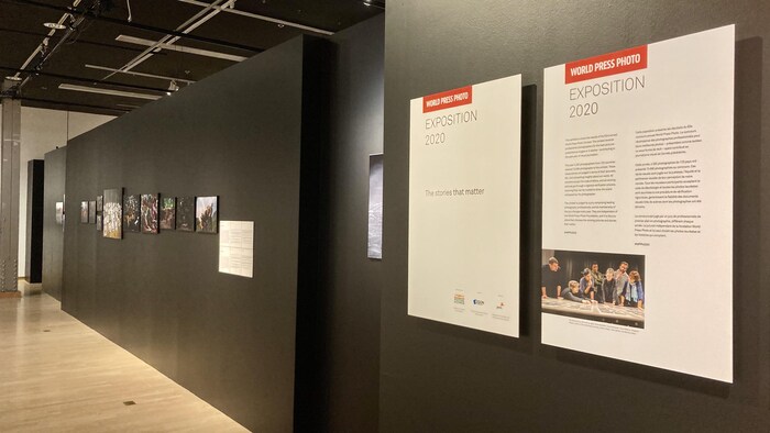 Des photographies sont accrochées dans une salle d'exposition.
